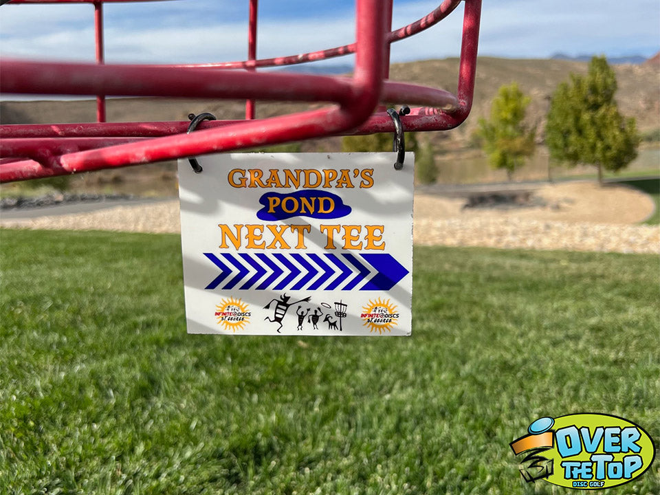 Hanging next tee directional sign for disc golf basket